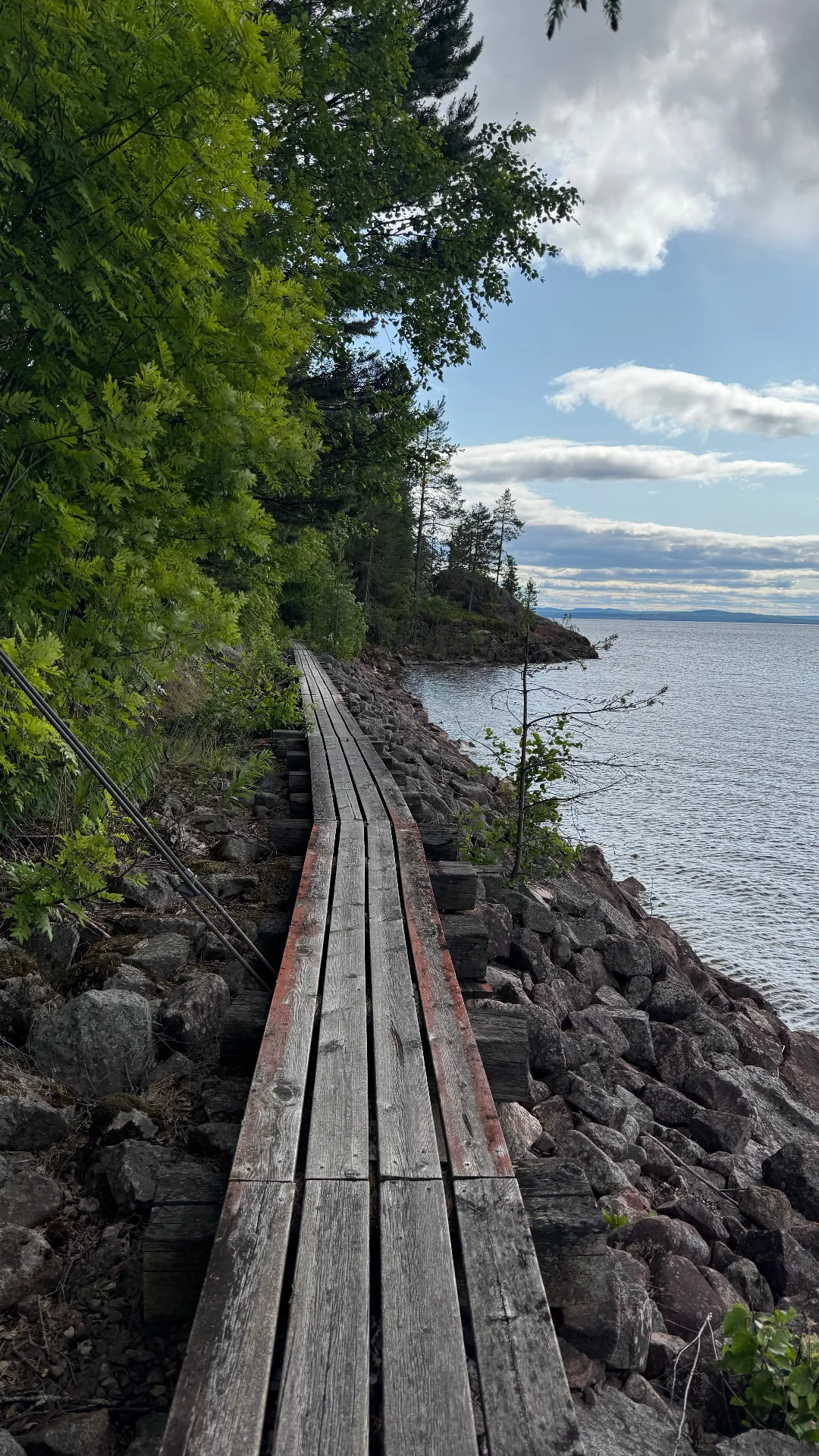 Boardwalk along a rocky shoreline. Expect slick planks after rain.